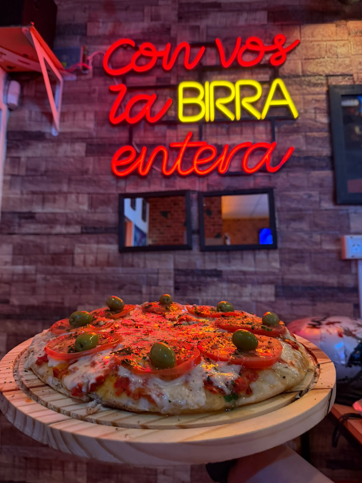 Pizza napolitana de Barfly bajo el neón Con vos la birra entera